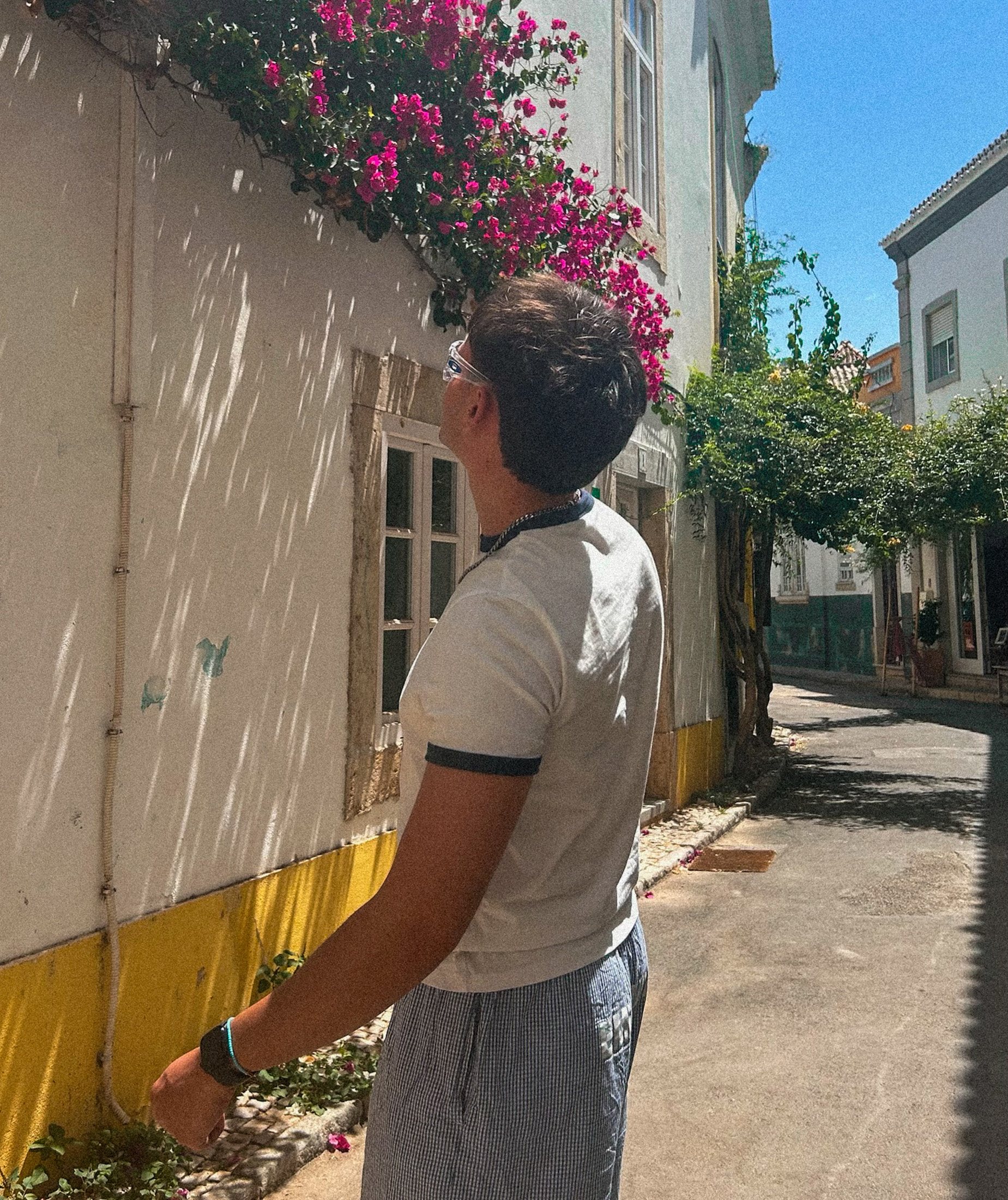 Raúl, diseñador gráfico, en una calle con buganvillas